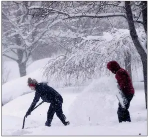  ?? AP/CHUCK BURTON ?? A couple shovel snow from their driveway Sunday in Greensboro, N.C. A strong winter storm caused icy roads, heavy snowfall and power failures throughout the South over the weekend.