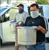  ?? Dan Watson/The Signal ?? (Left) Dozens of cars wait to pick up tamale dinner orders during Our Lady of Perpetual Help’s annual barbecue fundraiser in Newhall Friday. (Right) Church members Horacia Mendez, left, and Javier Reyna deliver some of the 800 pork, cheese and chicken tamales to the church for Friday’s dinner. Next up for the three-day event is today’s deep-pit barbecue beef dinner and virtual talent show.