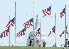  ?? MARK WILSON/GETTY IMAGES ?? A Park Service employee lowers the U.S. flags on the grounds of the Washington Monument to half-staff, on Monday in Washington, D.C.