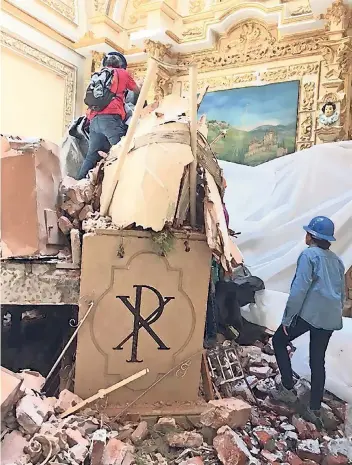  ??  ?? Una brigada especial del INAH rescata restos de la escultura entre los escombros de la cúpula del templo que colapsó.