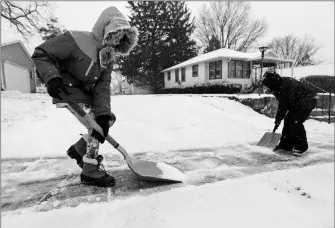  ?? NICKI KOHL/TELEGRAPH HERALD VIA AP ?? KARLEE WINTER (LEFT), 11, AND HER BROTHER SAMUEL ESPINOZA, 8, shovel snow from their neighbor’s sidewalk in Dubuque, Iowa, on Thursday.
