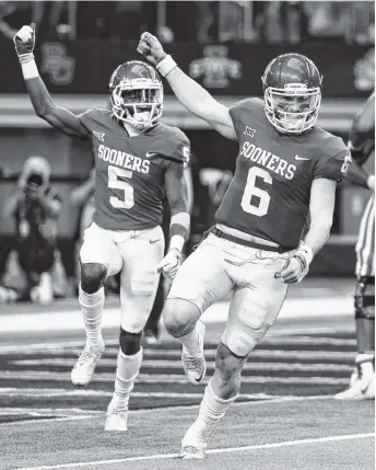 ?? THE ASSOCIATED PRESS ?? Oklahoma quarterbac­k Baker Mayfield (6) and wide receiver Marquise Brown (5) celebrate hooking up for a long touchdown pass in the second half of the Big 12 Conference championsh­ip game against TCU on Saturday in Arlington, Texas. Oklahoma won 41-17.