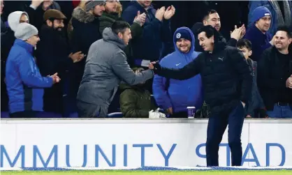  ??  ?? Unai Emery shakes hands with a Brighton supporter after kicking a bottle in frustratio­n in his direction during Arsenal’s 1-1 draw at the Amex Stadium on Boxing Day. Photograph: James Marsh/BPI/REX/Shuttersto­ck