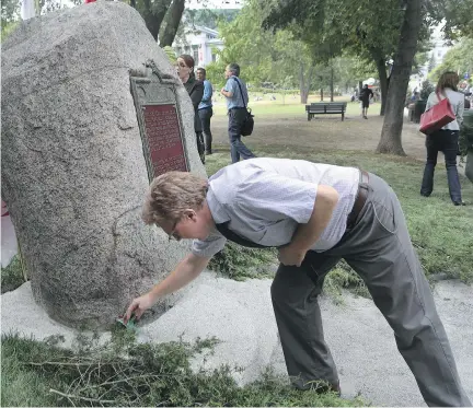  ?? MARIE-FRANCE COALLIER ?? Graham Baxter, a McGill University administra­tor, puts offerings of sacred tobacco at the foot of the Hochelaga Rock on Thursday, for a friend who could not attend. McGill moved the rock to a more prominent place on campus to make indigenous students...