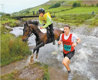  ??  ?? Hombres y caballos luchan por el primer lugar en una carrera repleta de obstáculos naturales