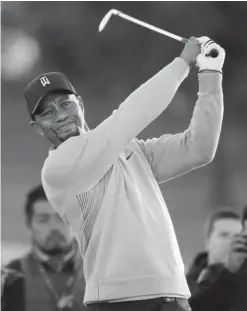  ?? — AP ?? SAN DIEGO: Tiger Woods watches his tee shot on the third hole of the north course during the Pro-Am event of the Farmers Insurance Open golf tournament yesterday, in San Diego.