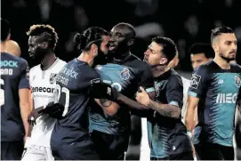  ?? Associated Press ?? Teammates try to stop Porto’s Moussa Marega, center, as he leaves the field after hearing monkey chants during a Portuguese league soccer match.