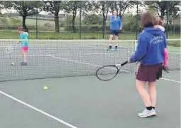  ??  ?? Sally and Nick Longley and family take to the tennis court again for a leisurely game of doubles at Ashbourne Tennis Club. Below, signs make the restrictio­ns clear to all who are taking part.