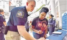  ?? AMY DAVIS/BALTIMORE SUN ?? Police cadet Nathan Keller shares informatio­n with Nautica Reynolds, 25, about joining the Baltimore County Police Department.