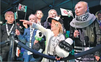  ?? PHOTOS BY AURORE BELOT / AFP; PATRICK POST/ AP ?? A group of children watch a big screen of the arrival of giant pandas female Wu Wen and male Xing Ya from China at Schiphol Airport in the Netherland­s on Wednesday. Some 300 showed up. Xing Ya is pictured as the pandas are introduced to the airport...