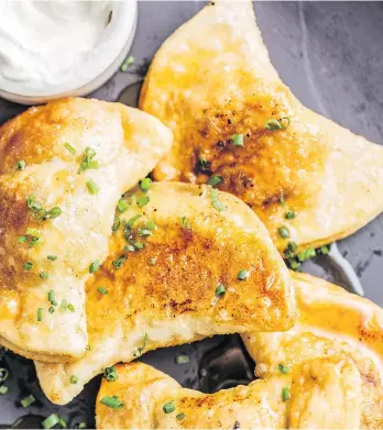  ?? HUGE GALDONES ?? Chef and cookbook author Matt Jennings finishes his cheddar and squash dumplings with a sprinkle of toasted sunflower seeds, a drizzle of sweet maple syrup and a dollop of sour cream on the side.