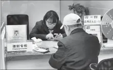  ?? PROVIDED TO CHINA DAILY ?? A consumer buys financial products in the lobby of a bank in Shanghai.