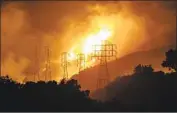  ?? MARCUS YAM Los Angeles Times ?? FLAMES FROM the Thomas fire whip around power lines in Sycamore Canyon in December 2017.