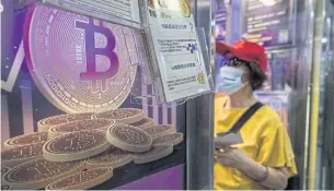  ?? AFP ?? A woman speaks with a worker at a cryptocurr­ency exchange in Hong Kong on April 15.