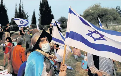  ?? REUTERS ?? A protester waves a flag during a demonstrat­ion against Prime Minister Benjamin Netanyahu’s new unity government in Jerusalem last week.