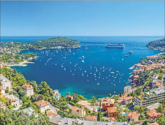  ?? elmvilla Getty Images ?? A CRUISE SHIP moors in the Bay of Villefranc­he, France, which was recently named the most beautiful Mediterran­ean port, with Cap Ferrat on the left.