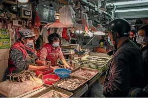  ?? GETTY ?? Residents wearing face masks purchase seafood at a wet market in Macau, China.
