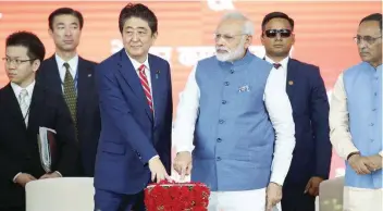 ?? — Reuters ?? Shinzo Abe (L) and Narendra Modi press a button at the groundbrea­king ceremony for a high-speed rail project in Ahmedabad on Thursday.
