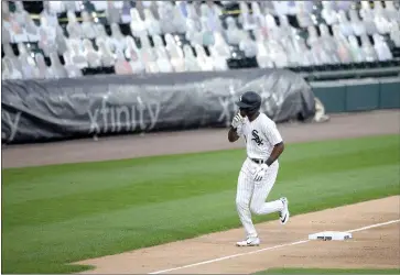  ?? Erin Hooley / Chicagotri­bune (above); Mike Ehrmann / Getty Images /TNS (left) ?? Chicago White Sox'stim Anderson rounds third base and the cardboard cutout fans after hitting a home run during the first inning of a game vs. the Detroittig­ers at Guaranteed Rate Field.tiger Woods and son Charlie Woods (left) fist-bump on the 18th green during the final round of the PNC Championsh­ip at the Ritz Carlton Golf Club in Orlando, Florida, on December 20, 2020.