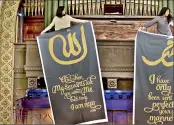  ?? The Wall Street Journal ?? Hasna Maznavi, right, and a friend hang banners for the Women's Mosque of America's first service this week. Pic courtesy