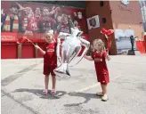  ?? Reuters ?? Children celebrate the victory of Liverpool at Anfield.
Liverpool won the English title for the first time in 30 years on Thursday after Manchester City’s defeat at Chelsea sealed the title for the Reds.