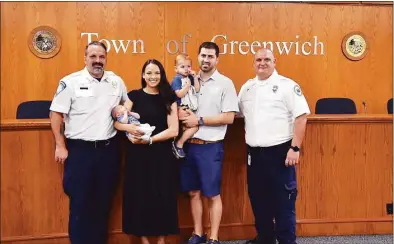  ?? Christian Abraham / Hearst Connecticu­t Media ?? Greenwich Emergency Medical Services EMT’s Anthony Vontobel, at left, Scott Baxter, at right, and volunteer Stephanie Busani (not present) were honored for helping save the life of Brittany Piro and her newborn baby Benjamin during a ceremony at Greenwich Town Hall in Greenwich on Wednesday. Also pictured is dad Matt Piro with their other son Dean, 2. The three EMT workers were able to utilize their training when Brittany went into early labor and started bleeding and for getting her to Greenwich Hospital quickly.