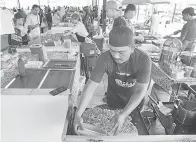  ?? ?? TUMPUAN RAMAI: Fairun sedang menyediaka­n ‘roti John’ di gerainya di Bazar Ramadan Kem Tentera Penrissen Batu 8.