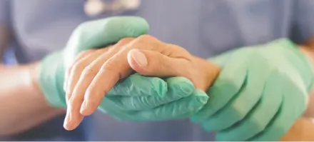  ?? GETTY ?? A physician holds a patient’s hand during an assessment for medically assisted death.