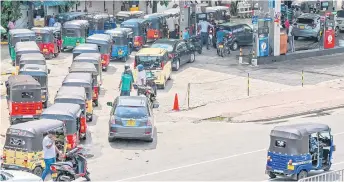  ?? — AFP photo ?? Motorists queue up to buy fuel at a Ceylon Petroleum Corporatio­n fuel station in Colombo.