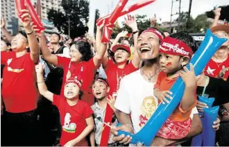  ?? Mark Baker / Associated Press ?? Supporters of Myanmar’s National League for Democracy party cheer as election results are posted Monday outside the NLD headquarte­rs in Yangon.