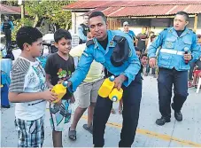  ??  ?? SEGURIDAD. Los agentes policiales comparten con los niños.