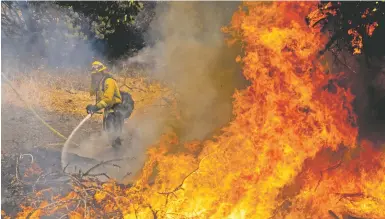  ?? PHOTOS BY NOAH BERGER/ASSOCIATED PRESS ?? A firefighte­r battles the Oak Fire on Saturday in Mariposa County, Calif.