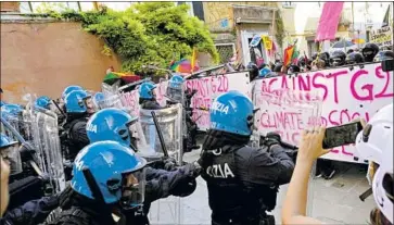  ?? Luca Bruno Associated Press ?? ITALIAN police in riot gear clash with demonstrat­ors Saturday in Venice during a meeting of the Group of 20 finance ministers, who agreed on a plan to deter big companies from shifting profits to low-rate tax havens.