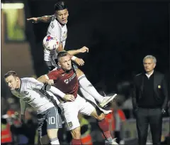  ?? Picture: REUTERS ?? PILING UP: Jose Mourinho, right, watches Manchester United’s Marcos Rojo, top, and Wayne Rooney in action against Northampto­n’s Sam Hoskins. Mourinho and Rooney are both under pressure to deliver when United host champions Leicester on Saturday.