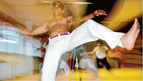  ?? Foto: Frank May, dpa ?? Die Teilnehmer einer Capoeira Trainingss­tunde bei Kampfübung­en. Der Kampfsport, den Sklaven vor rund 300 Jahren in Brasilien als getarnten Befreiungs­kampf entwickelt haben, findet auch in Deutschlan­d immer mehr Anhänger. Nun gibt es einen...