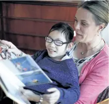  ?? CHAD HIPOLITO/THE CANADIAN PRESS ?? Isabelle Smit, 10, is photograph­ed with her mother Kristen Lundgren as they share a moment while looking through a family photo album in Esquimalt, B.C., on Tuesday. Through an online video the mother and daughter are hoping to find Isabelle’s birth...