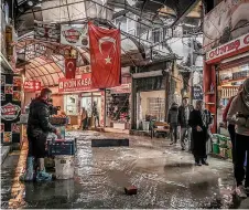  ?? ?? People try to avoid the flood water at the Uzuncarsi Bazzar following heavy rains, eleven months a er a 7.8-magnitude earthquake jolt and a ershocks wiped out swathes of Turkey’s mountainou­s southeast, in Antakya