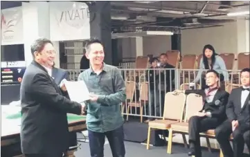  ??  ?? Yeo receives his certificat­e for attending a referee’s course in Kuala Lumpur.