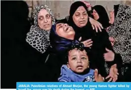  ??  ?? JABALIA: Palestinia­n relatives of Ahmad Murjan, the young Hamas fighter killed by Israeli fire, mourn over his death during the funeral. — AFP