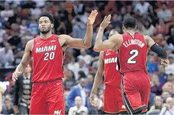  ?? LYNNE SLADKY/AP ?? Miami Heat's Justise Winslow (20) high-fives Wayne Ellington (2) during Sunday’s game against the Bucks.