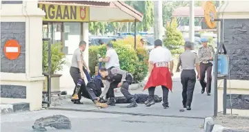  ??  ?? Police remove the bodies of attackers who were shot and killed at the entrance of a police station in Pekanbaru, Indonesia in this photo taken by Antara Foto. — Reuters photo