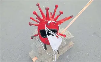  ?? REUTERS ?? A coronaviru­s-shaped helmet and protective mask kept on the road during an awareness drive in the Capital. n