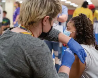  ?? BOstON Herald file ?? DOING ITS JOB: Registered Nurse Katrina Rosenberg administer­s the first dose of Pfizer's COVID-19 vaccine to Ashley Moran, 12, of Everett on Aug. 30.