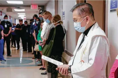  ?? Michael Wyke / Contributo­r ?? Father Anthony Tran, right, reads a prayer at the New Latino Health Center of Excellence at the St. Joseph Medical Center.