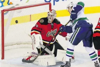  ?? Christina Ryan/calgary Herald ?? Vancouver Canucks Zac Dalpe watches the puck miss against Calgary Flames goalie Reto Berra Sunday at the Scotiabank Saddledome. Berra has a 5-10-2 record going into Tuesday’s game.