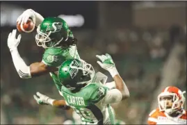  ?? The Canadian Press ?? Saskatchew­an Roughrider­s defensive back Ed Gainey outleaps teammate Duron Carter to record his fourth intercepti­on during second-half CFL action against the B.C. Lions in Regina on Sunday.The Lions lost 41-8.