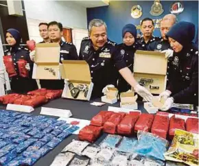  ?? PIC BY RAMDZAN MASIAM ?? Penang deputy police chief Datuk Roslee Chik (fourth from left) showing the seized drugs and firearms at the state police headquarte­rs in George Town yesterday.