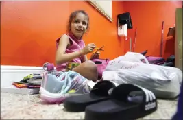  ?? ?? Delmis Benbow Tamayo, 8, finds a pair of children’s scissors in a backpack with school supplies that was donated to her family on Feb. 21in Hialeah, Fla. Delmis, her mother and two siblings arrived by sea to the U.S. from Cuba. Delmis started school the following day.