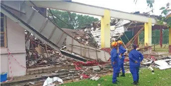  ??  ?? Civil Defence Force personnel assess the building and its surroundin­g site.