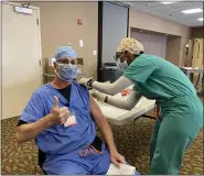  ?? PHOTO COURTESY ASHLEY JEFFERSON ?? Robert Karpac, a nurse anesthetis­t at Abington – Lansdale Hospital in Lansdale, dons a mask as he receives a COVID-19 vaccine Friday morning.